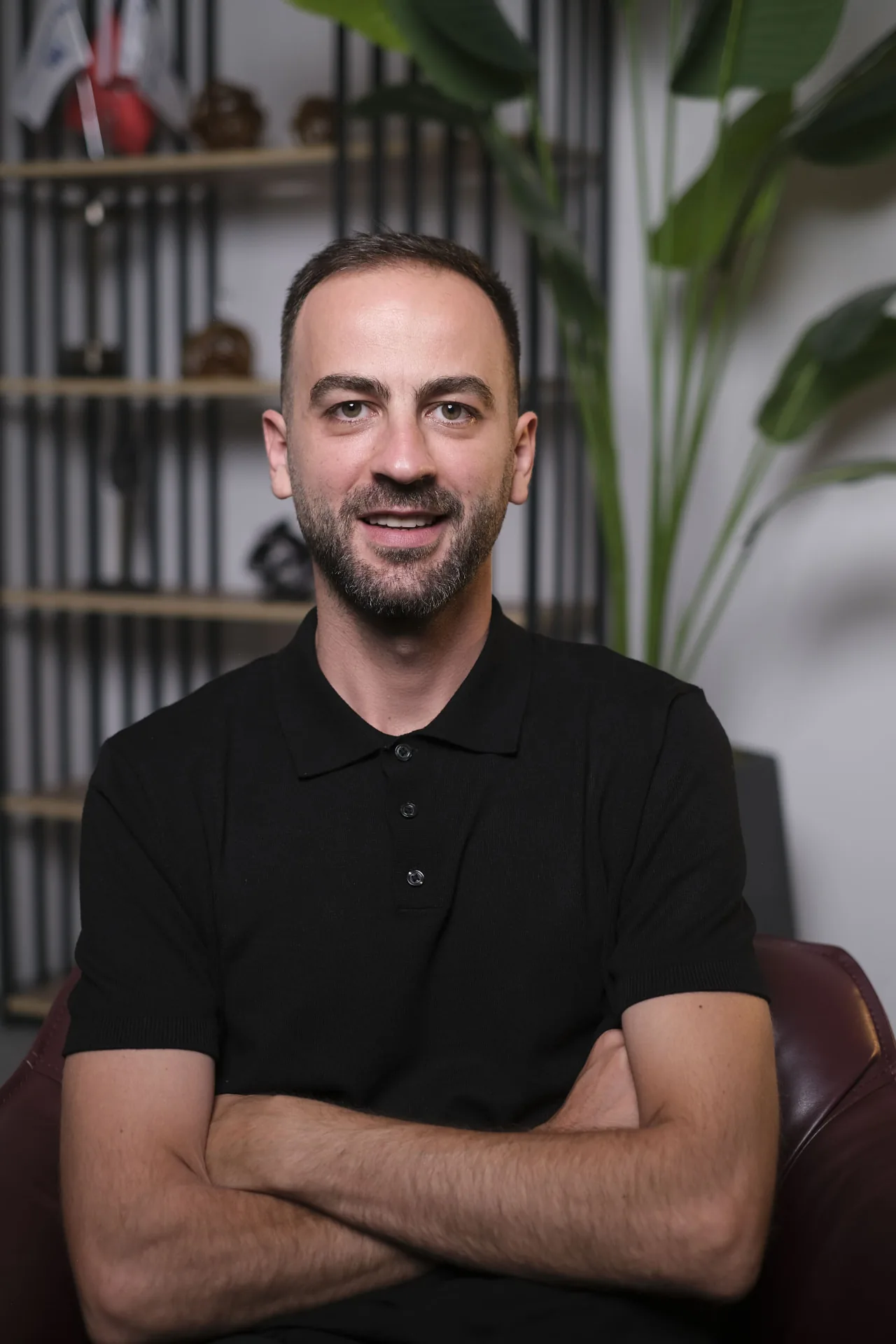 Diyetisyen Yusuf Gül, siyah polo tişörtle kolları çapraz duruyor